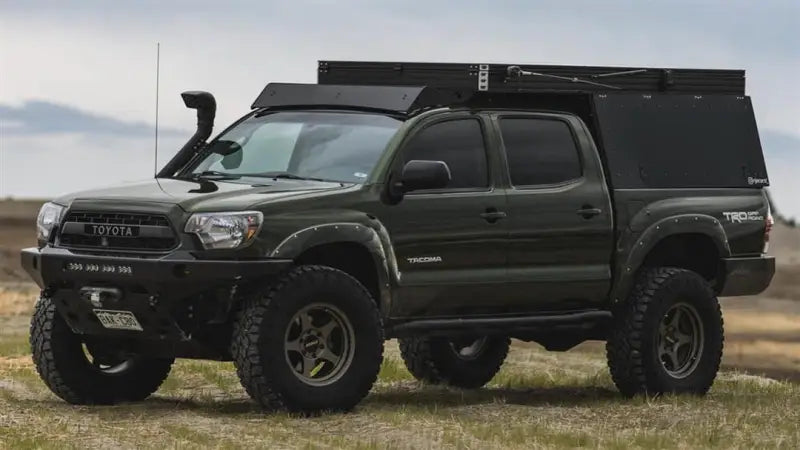 Modified green Toyota Tacoma with Sherpa Equip Tacoma Camper for awesome camping experience