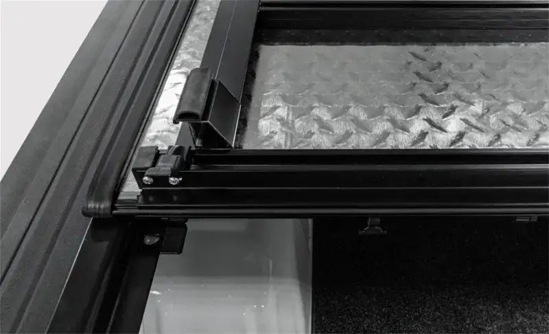 Access Lomax tri-fold cover with diamond plate truck bed and black frame for Ram 1500
