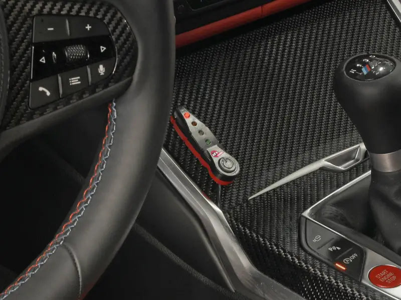 Interior of BMW M3 M4 with black leather steering wheel and afe scorcher bluetooth power module