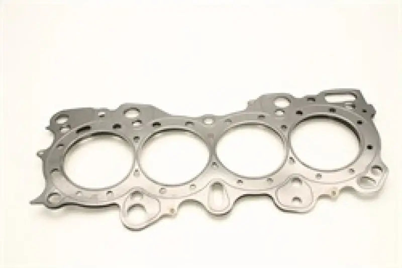 The Cometic Honda CRX/Civic/Integra VTEC 81mm .030 inch MLS Head Gasket by Cometic Gasket is displayed against a white background, featuring four large circular openings for the VTEC 81mm engine. This metallic gasket is compatible with Honda CRX, Civic, and Integra models and includes multiple smaller holes within its complex, irregular outer shape.