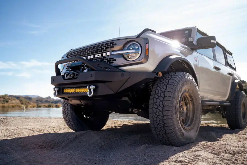DV8 Offroad 2021+ Ford Bronco Modular Front Bumper Winch Capable with Auxiliary Light Mounts on SUV by water