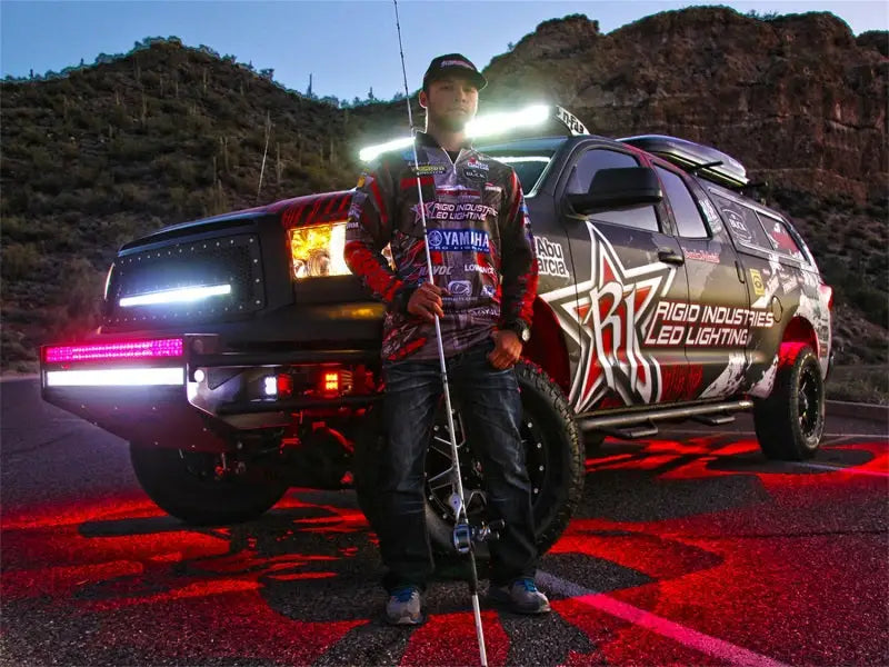 Night offroading vehicle equipped with Rigid Industries Rock Light Kit - Blue (6 lights), illuminating the terrain with vibrant LED lighting, enhancing visibility and style.