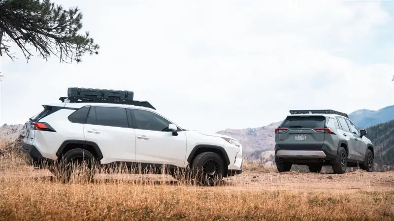 Two rugged Toyota RAV4 SUVs with black anodized roof racks and direct fit setup