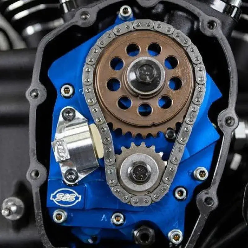Blue S&S motorcycle engine with silver cam chain and bronze sprocket
