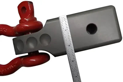 Factor 55 Hitchlink Pro 2.5 for 2.5' receivers showcasing durable construction with a red hitch accessory and measurement tool.