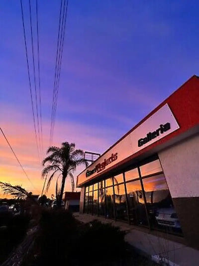 Storefront of Racing Products Galleria with a sunset sky in the background.