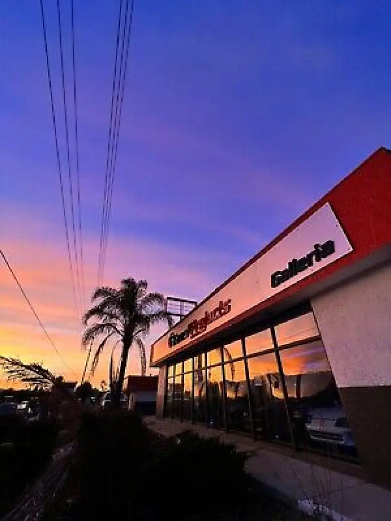 Storefront of Racing Products Galleria with a sunset sky in the background.