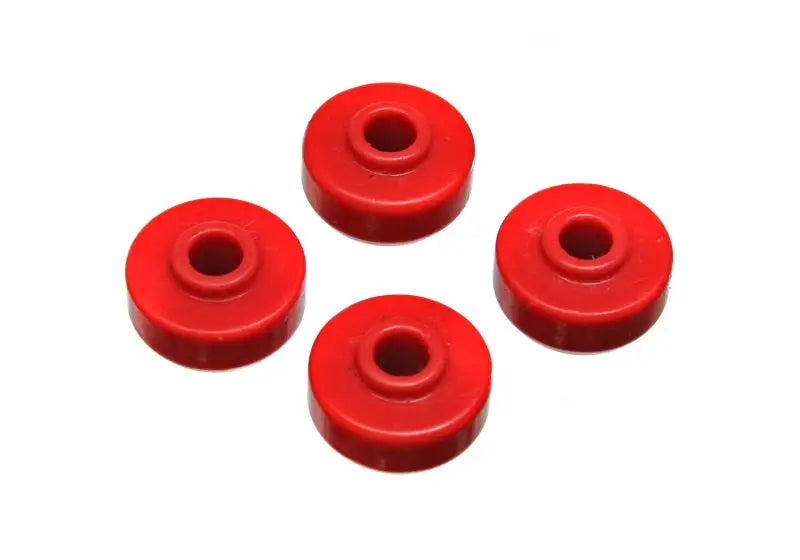 Four pieces from the Energy Suspension Universal Red Shock Bushing Set, crafted from performance polyurethane by Energy Suspension, are arranged in a diamond pattern on a white background.