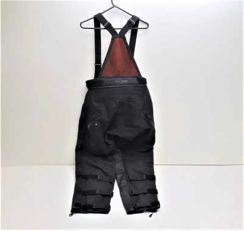 Black Firstgear Rogue Rogue XC Pro pants with red chest panel and adjustable straps
