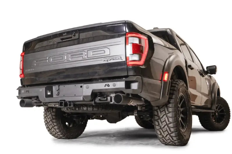 FR21-W5351-1 Fab Fours Premium Rear bumper installed on a rugged off-road vehicle, showcasing its high-quality construction and aggressive appearance.