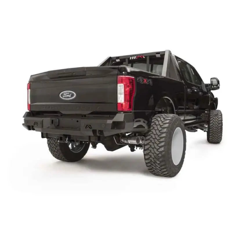 FS17-W4151-1 Fab Fours rear sensor bumper installed on a lifted Ford Super Duty F250-F350, featuring a rugged design with integrated sensor openings and robust construction for off-road protection and enhanced style.