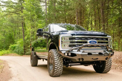 FS23-X5952-1 Fab Fours Matrix Front on a rugged off-road truck in a forest setting, showcasing high-quality construction and aggressive styling for maximum protection, Bumpers, Grilles & Guards, AVADA - Best Sellers, Must Haves