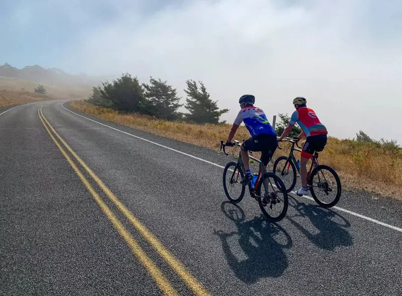 Cyclists riding on a winding road with Highway 21 30 header highway battery display