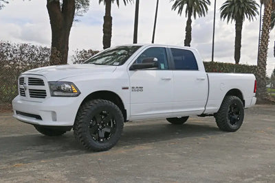 White Dodge Ram 1500 4WD with ICON 09-18 Ram 1500 4WD .75-2.5in Stage 4 Suspension System parked outdoors.