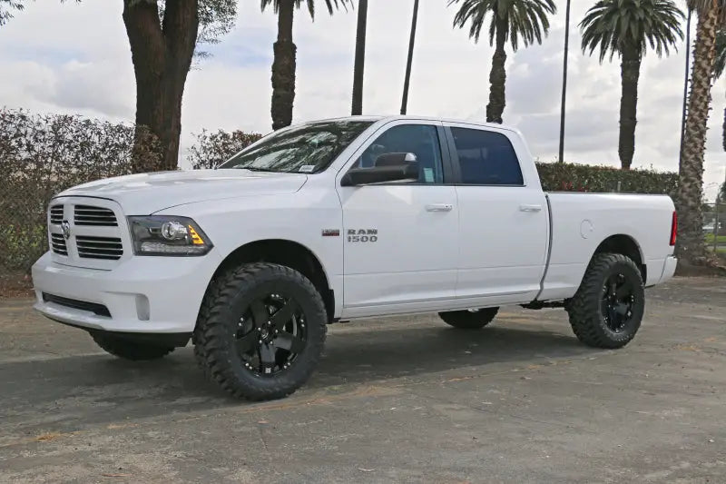 White Dodge Ram 1500 4WD with ICON 09-18 Ram 1500 4WD .75-2.5in Stage 4 Suspension System parked outdoors.