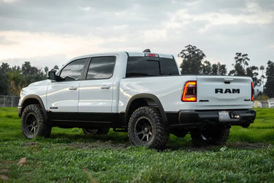 ICON Vehicle Dynamics 2019+ Ram 1500 with .75-2.5in Stage 1 Suspension System, shown lifted with aggressive tires in grassy outdoor setting.