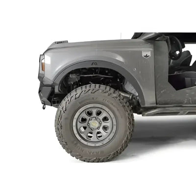 Fab Fours 21-22 Ford Bronco accessory relocation bracket installed on a gray Ford Bronco's front tire area, showcasing durable construction and precise fit.