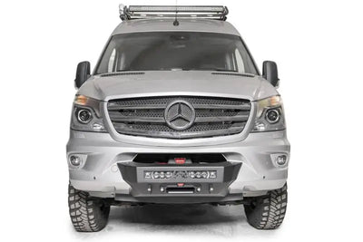 Silver Mercedes Sprinter van with Fab Fours winch mount, rugged tires and roof light bar