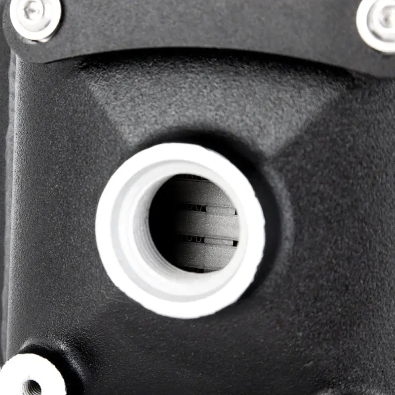 Black metal mishimoto universal air-to-water intercooler part with white rimmed hole