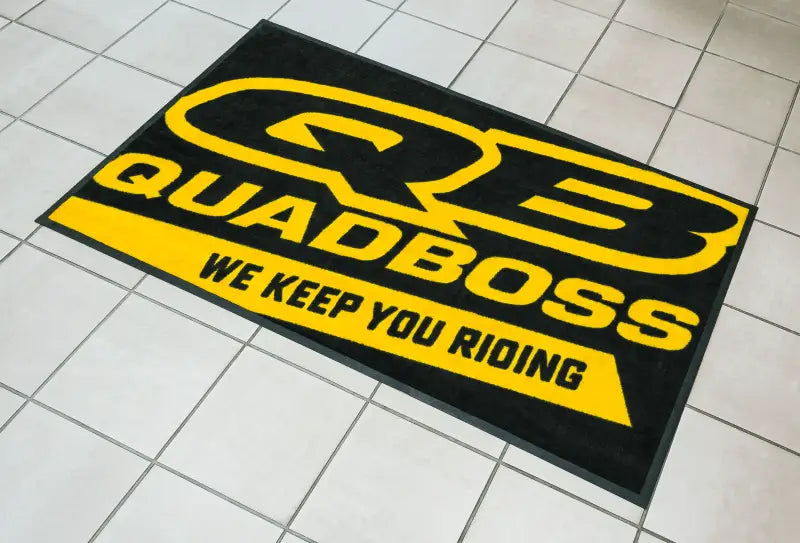 Quadboss 3x6 floor shop mat in black and yellow with bold text design