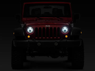 Red Jeep Wrangler with illuminated LED Daymaker headlights in chrome housing