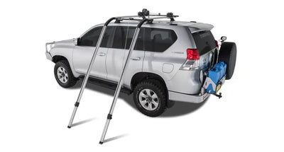 Silver SUV with roof rack and spare tire using Rhinorack Nautic Kayak Lifter for kayak hauling