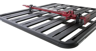 Rhino-Rack Pioneer High Lifting Jack Holder Bracket Set (Top Mount) securely attached to a black Rhino-Rack Pioneer system, holding a red high lifting jack.