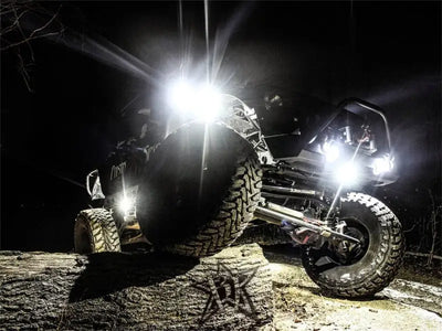 Off-road vehicle illuminated by Rigid Industries Rock Light Kit in Cool White, featuring six powerful LED lights for enhanced night rock crawling and trail lighting.