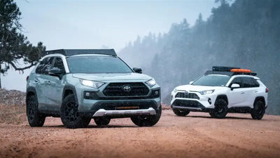Two Toyota RAV4 SUVs with black anodized roof racks and direct fit setup