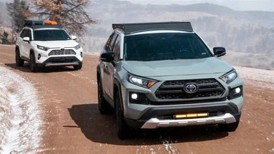 Two Toyota RAV4 SUVs with black anodized direct fit roof racks and accessories