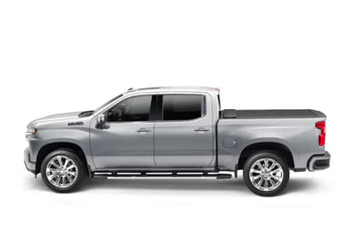 Silver crew cab pickup truck with a power retractable tonneau cover in matte black