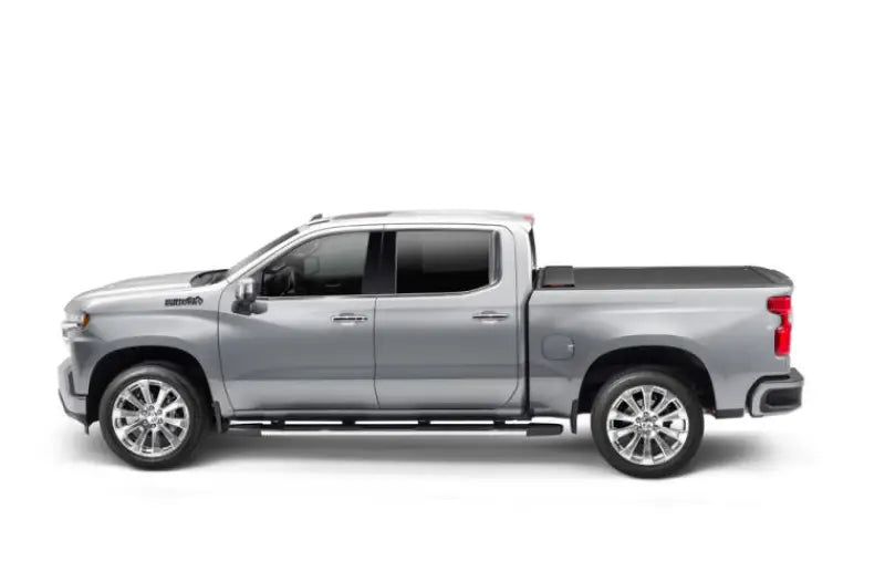 Silver crew cab pickup truck with a power retractable tonneau cover in matte black